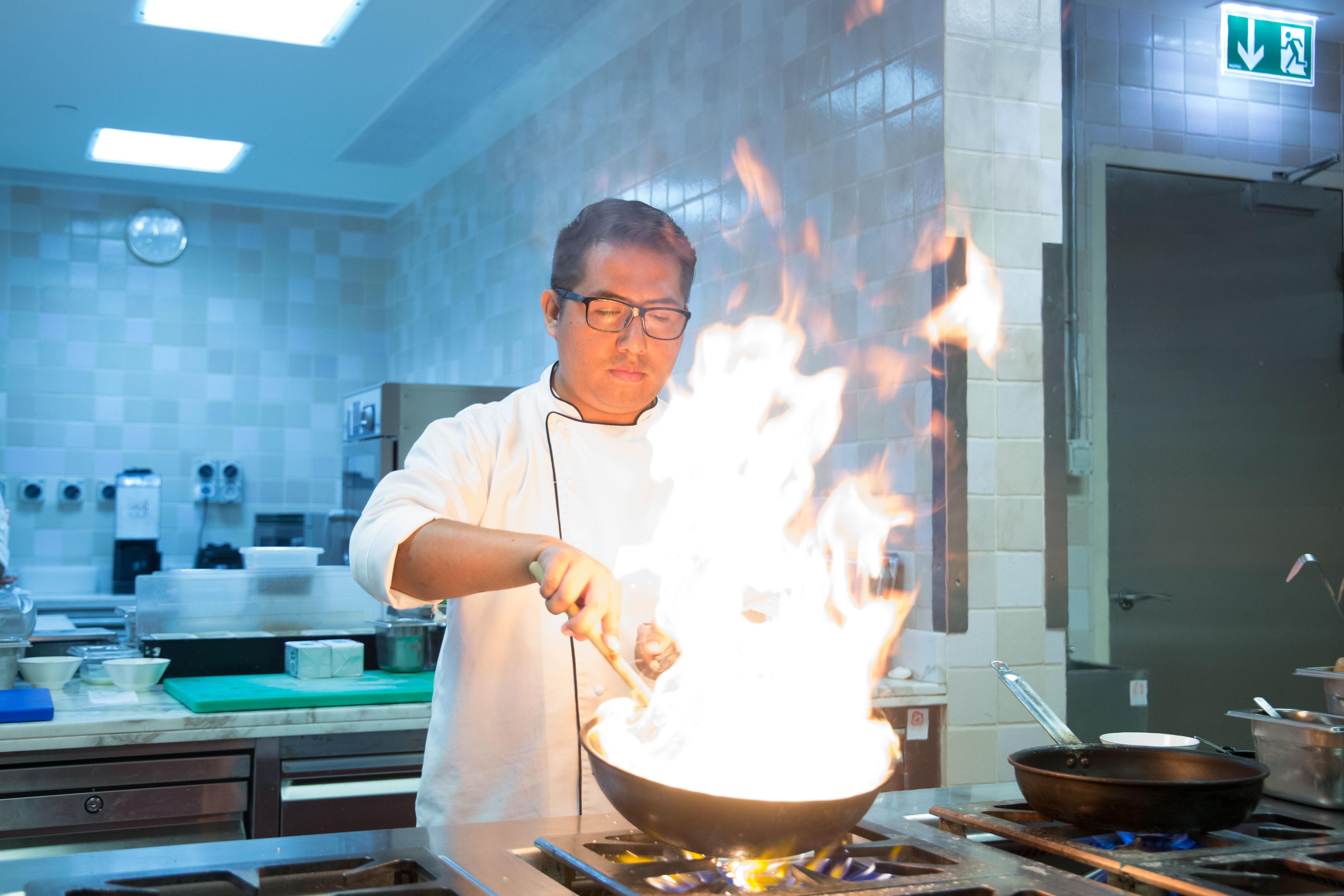 Bab Al Qasr Hotel Abu Dhabi Esterno foto A chef cooking with a wok